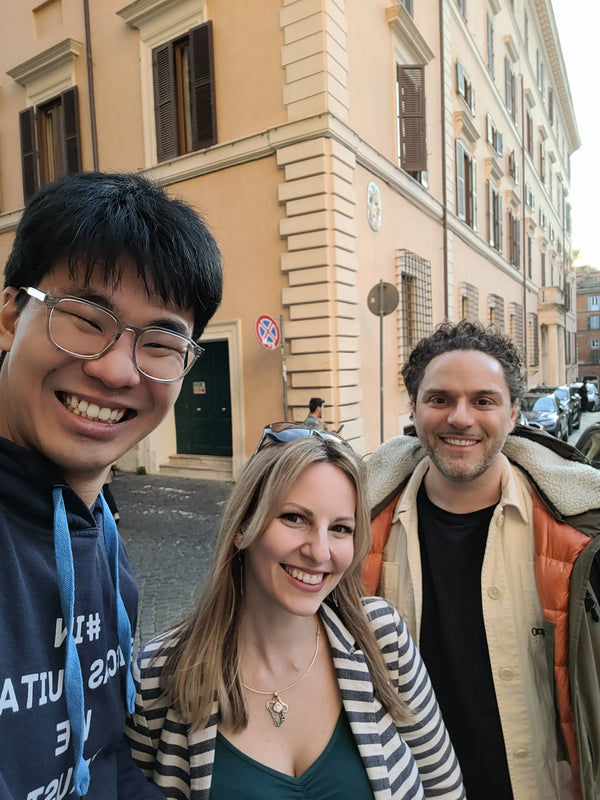 Three people posing for a selfie in front of a building