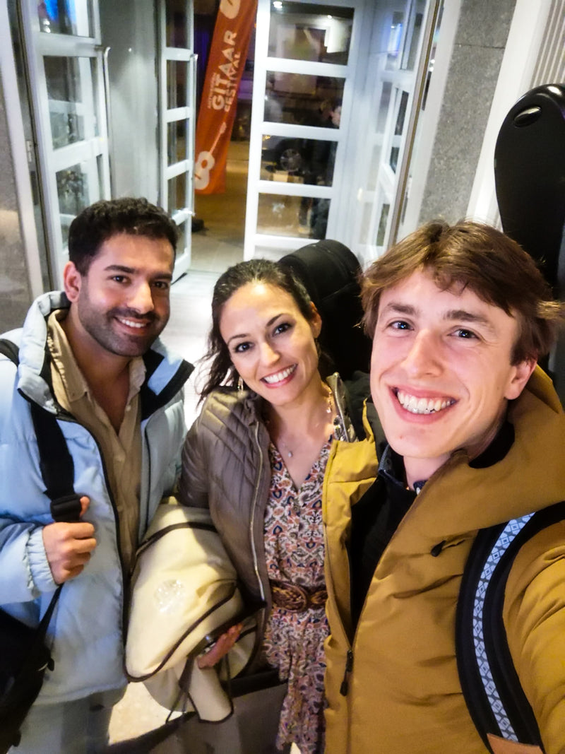 Three people posing for a selfie in an indoor setting with a store in the background.