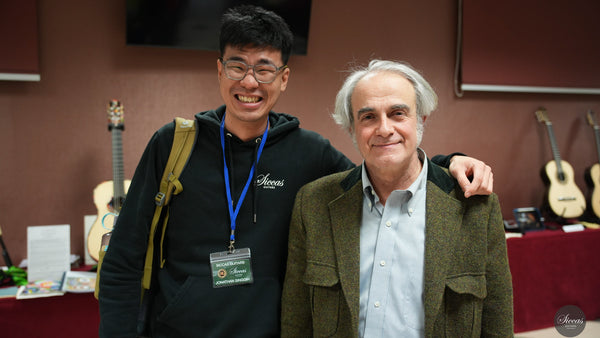 Two men standing together with musical instruments in the background